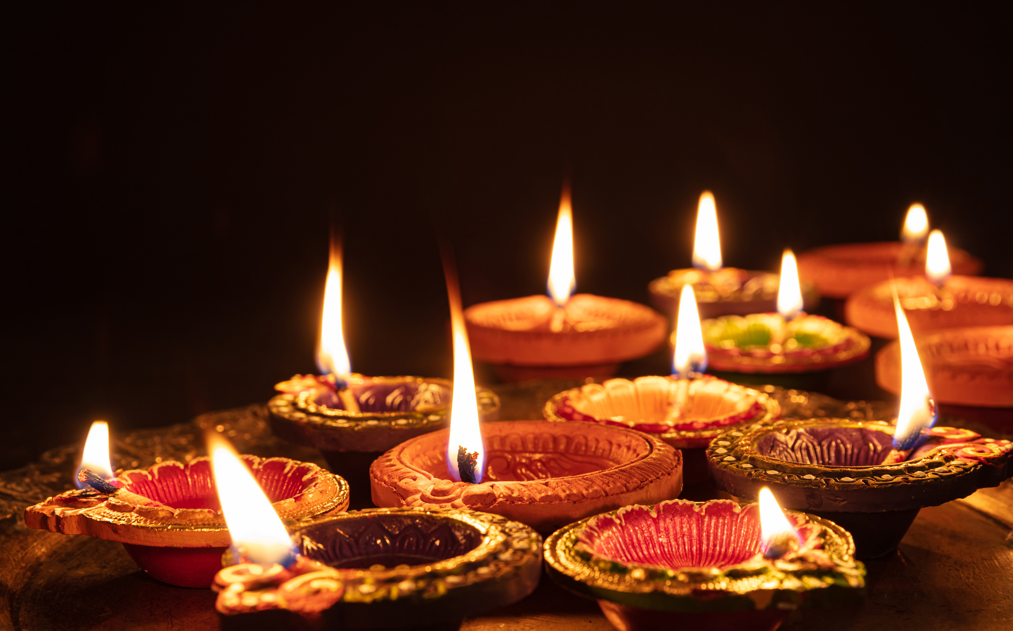 Diwali, Hindu festival of lights celebration. Diya oil lamps against dark background,