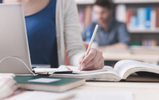 person studying with a notebook and computer