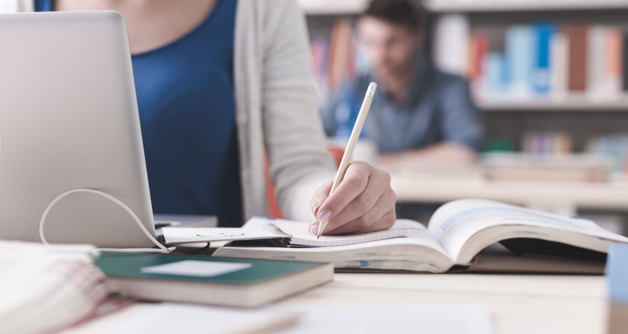 person studying with a notebook and computer