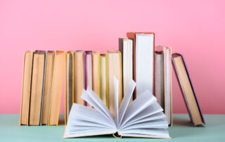 books leaning against a pink wall