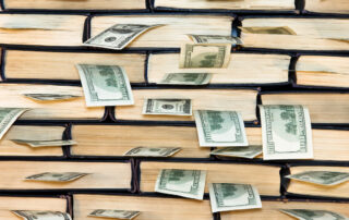 wall of books with money sticking out of each book