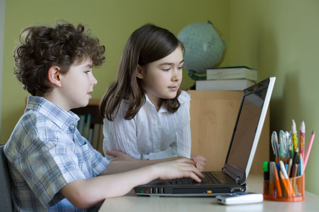 two students playing math games on a computer