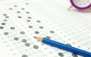 Pencil and alarm clock on test sheet on isee test day