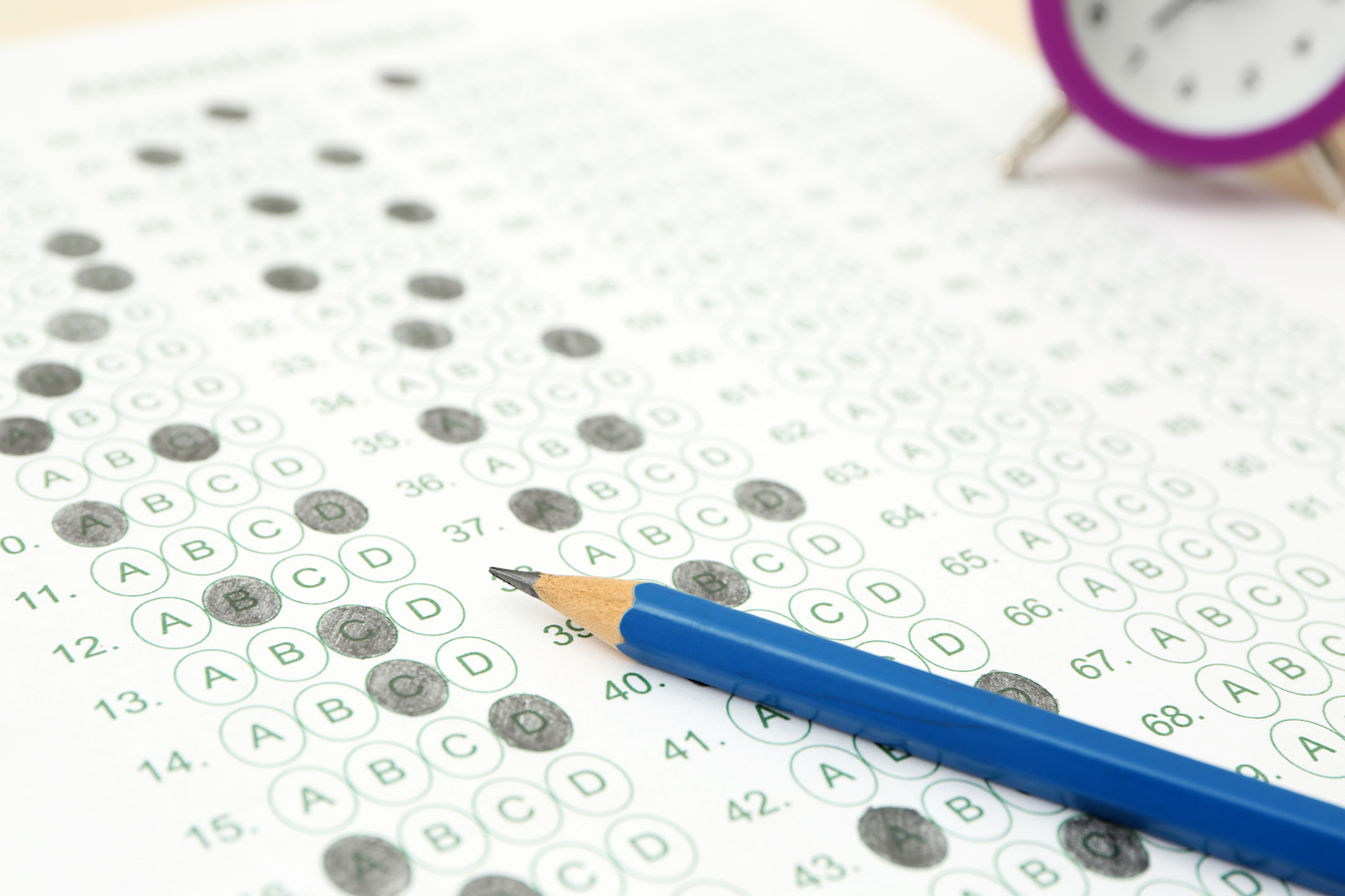 Pencil and alarm clock on test sheet on isee test day