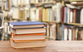 stack of books for sat and act prep in a library