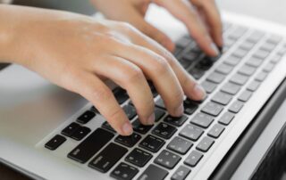 Closeup of hands typing, taking the digital PSAT exam