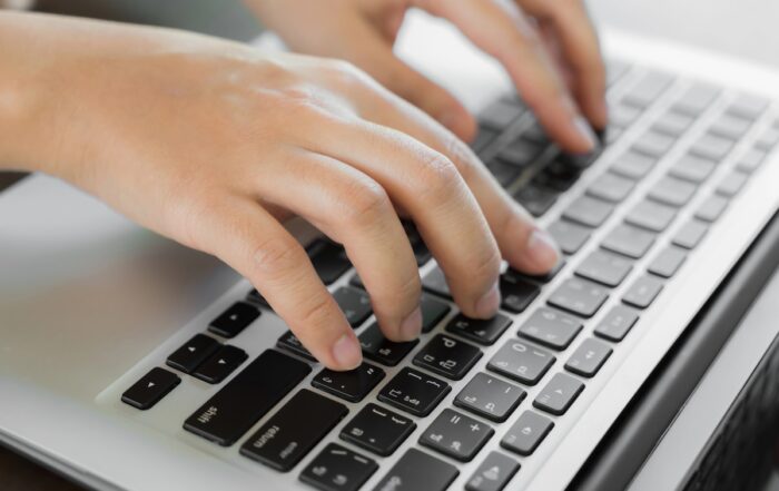 Closeup of hands typing, taking the digital PSAT exam