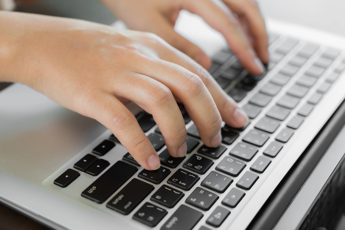 Closeup of hands typing, taking the digital PSAT exam