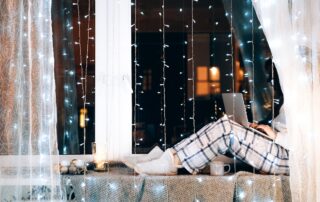 person sitting on a cozy windowsill having a productive winter break.