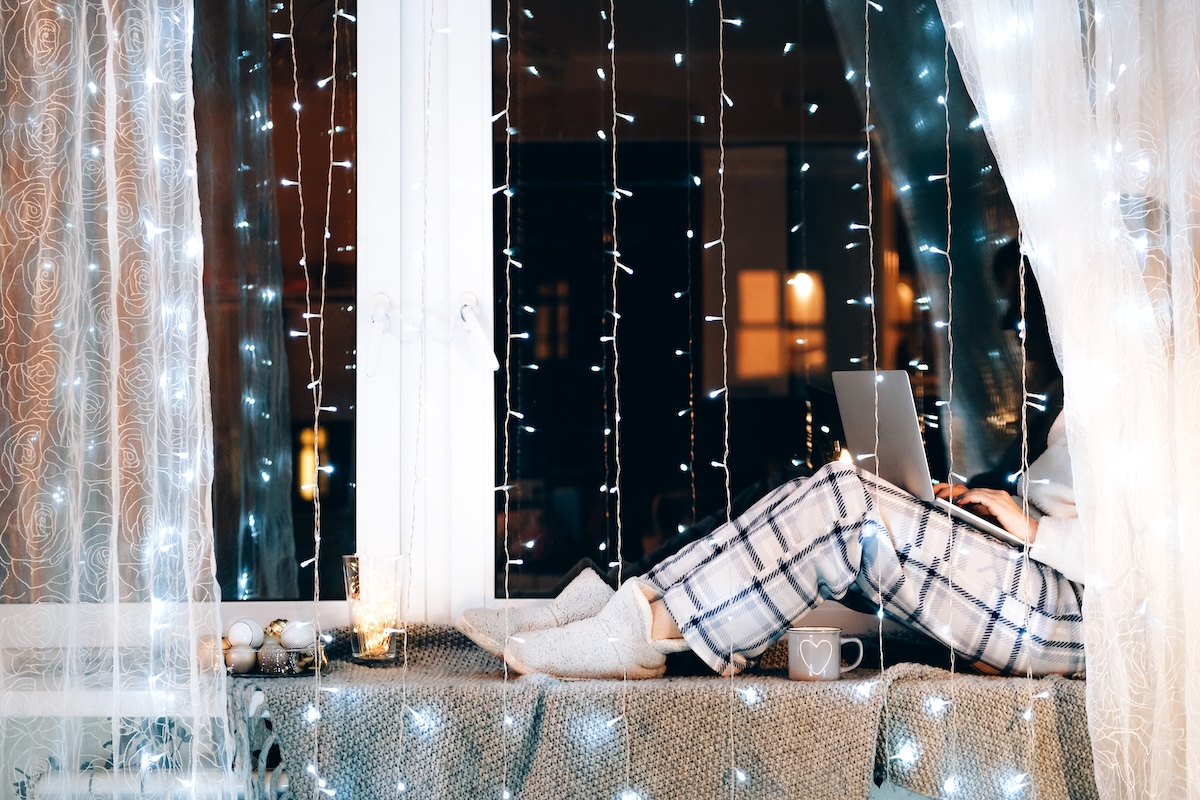 person sitting on a cozy windowsill having a productive winter break.